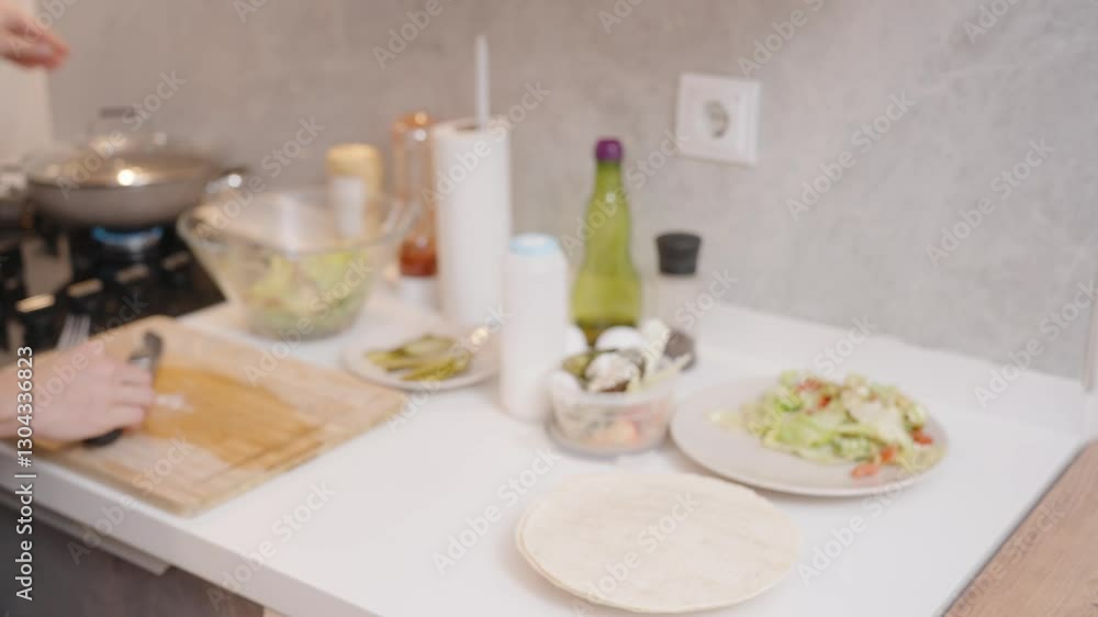 Person Cracking Egg into Frying Pan on Gas Stove with Sausages Cooking in Modern Kitchen with Marble Backsplash. Breakfast Preparation Concept Person Cracking Egg into Frying Pan on Gas Stove with Sausages Cooking in Modern Kitchen with Marble Backsplash. Breakfast Preparation Concept