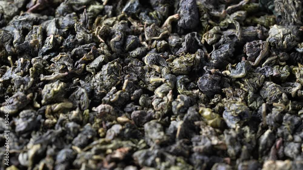 Pile of green dry leaves of tea oolong with milk aroma, close up. Background of dried green tea leaves, rotates, macro Pile of green dry leaves of tea oolong with milk aroma, close up. Background of dried green tea leaves, rotates, macro