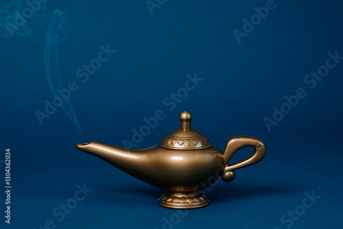 Magic lamp with smoke in a studio setting on a blue background