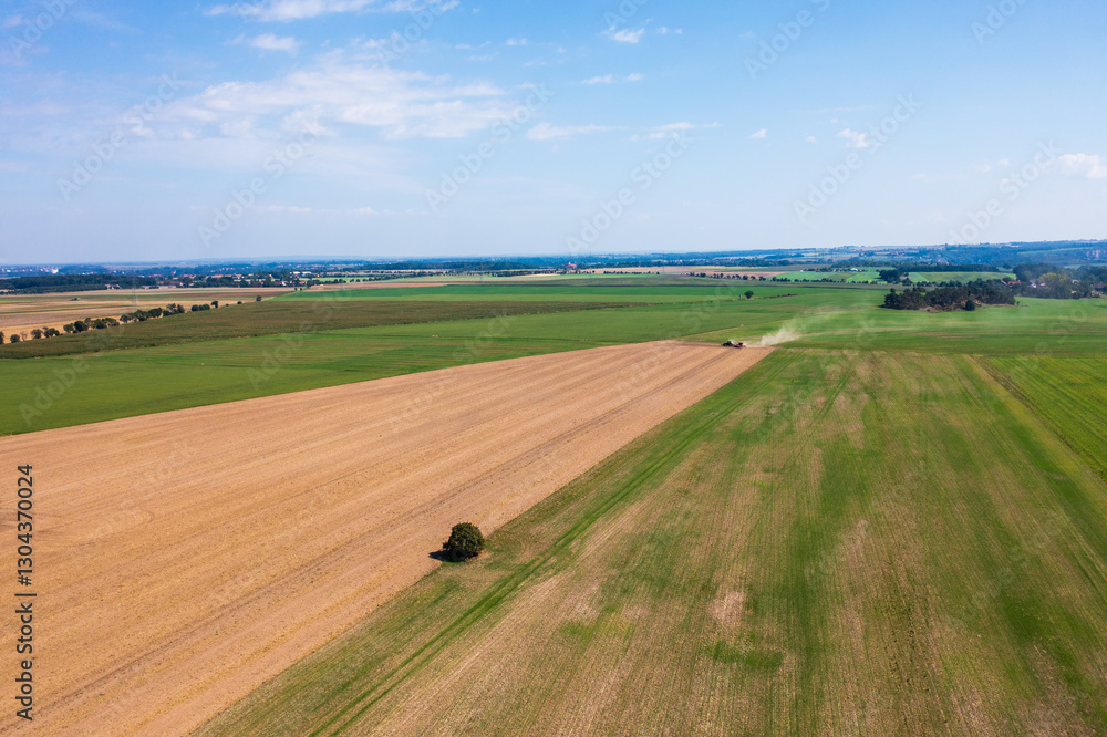 Obraz premium Aerial view an agricultural field, tractor tilling land. Smooth lines plowed soil emphasize scale agricultural work. Farmers labor, preparation for planting season, agricultural development.