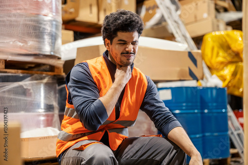 Tableau sur toile An ill interracial warehouseman with sore throat frowning.