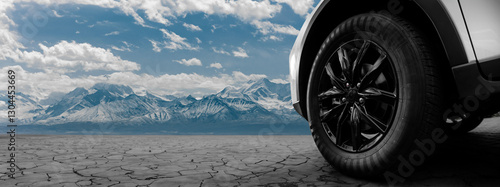 A car tire is shown in front of a mountain range