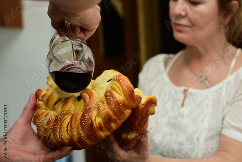 Canvas Print Pouring wine onto traditional festive bread celebrating patron saint day