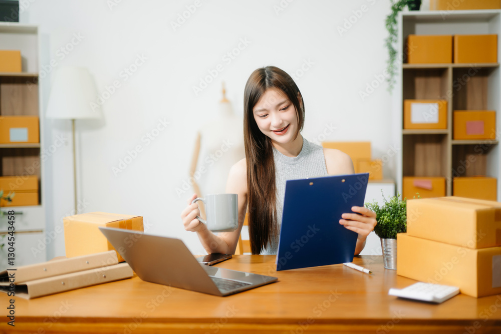 Young business owner woman prepare parcel box and standing check online orders for deliver Young business owner woman prepare parcel box and standing check online orders for deliver