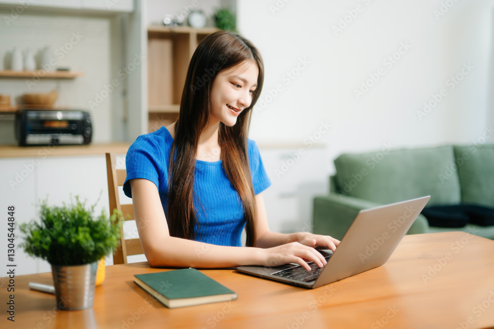 Happy woman with headphones working on a tablet in a bright kitchen. Ideal for themes of remote work Happy woman with headphones working on a tablet in a bright kitchen. Ideal for themes of remote work