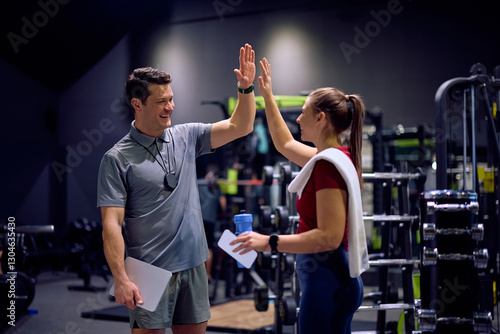 Wallpaper Mural Happy personal trainer and athletic woman giving high-five after successful workout in a gym. Torontodigital.ca