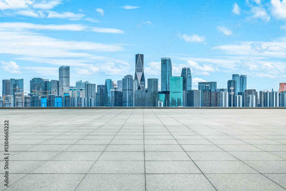 Modern city skyline with empty tile floor under blue sky Modern city skyline with empty tile floor under blue sky