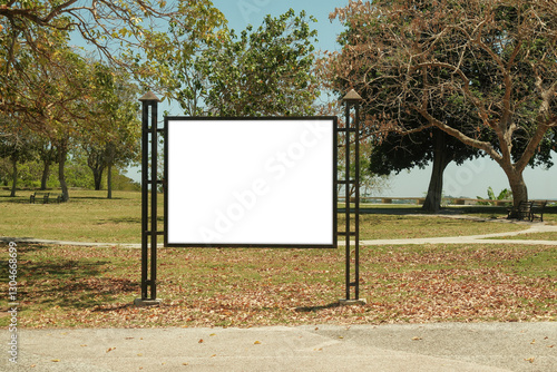 Mock up template: Horizontal billboard out of home (OOH) advertising poster in public park, Display held by iron metal frame design, installed on grass. Trees in background; bright sunny day.