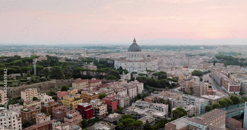 Drone shot of Vatican City, highlighting the iconic St. Peter Basilica and surrounding architecture. Warm sunrise glow enhances beauty of this religious and historical landmark. Drone shot of Vatican City, highlighting the iconic St. Peter Basilica and surrounding architecture. Warm sunrise glow enhances beauty of this religious and historical landmark.
