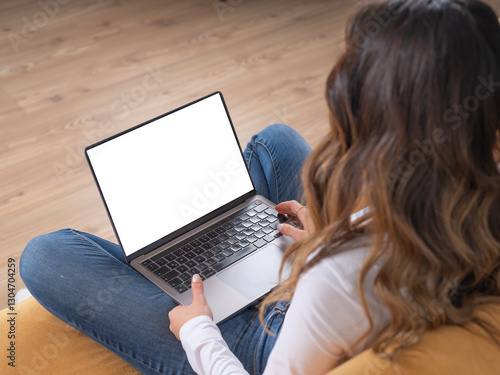 Over shoulder laptop mock up, young caucasian teen girl student relax sit on sofa holding notebook computer looking white empty blank screen. Online learning, using web site application, close up.