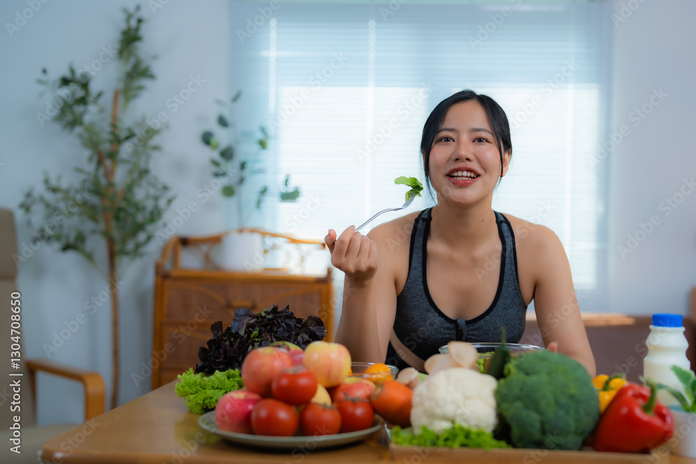 Beautiful asian sportswoman eating a portion of fresh salad in her modern and bright apartment, enjoying a healthy lifestyle and taking care of her body Beautiful asian sportswoman eating a portion of fresh salad in her modern and bright apartment, enjoying a healthy lifestyle and taking care of her body