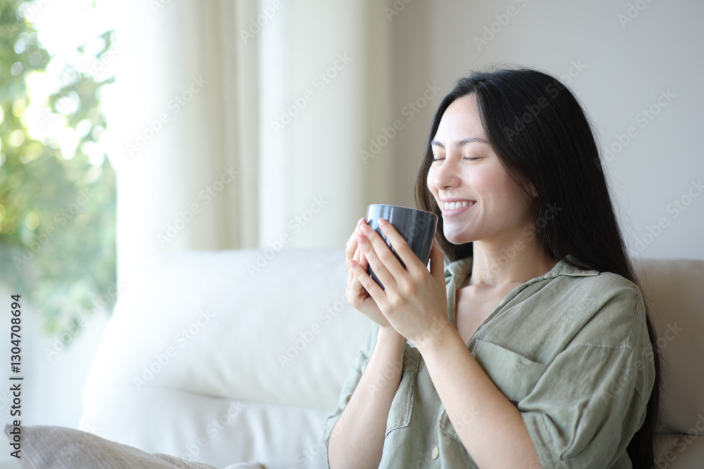Happy asian woman smelling coffee aroma at home Happy asian woman smelling coffee aroma at home