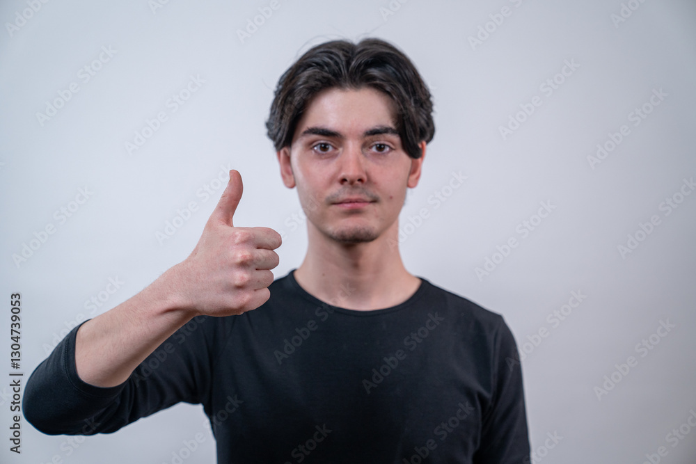 The young man showing ok sign with a thumbs up isolated on white background. The young man showing ok sign with a thumbs up isolated on white background.