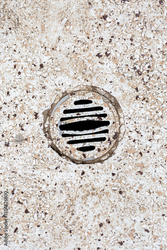 Stone floor with water drain in public toilet
