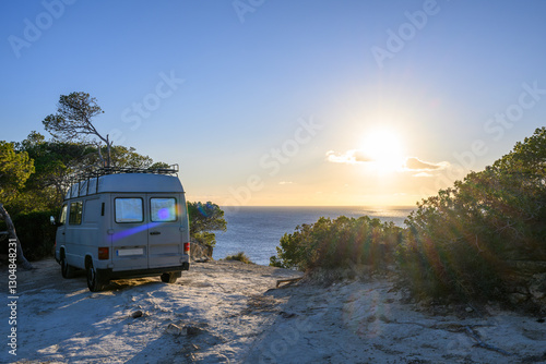 Old motorhome on the beach with sun and sea in the background, Mallorca, Spain