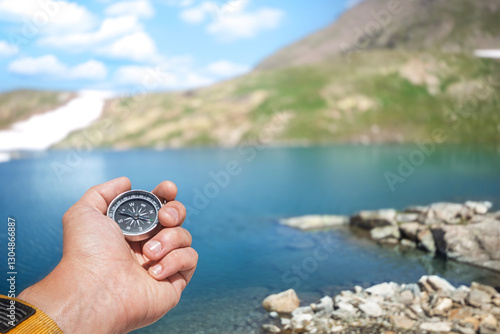 Traveler Holding a Compass Against a Mountain Lake in the Caucasus