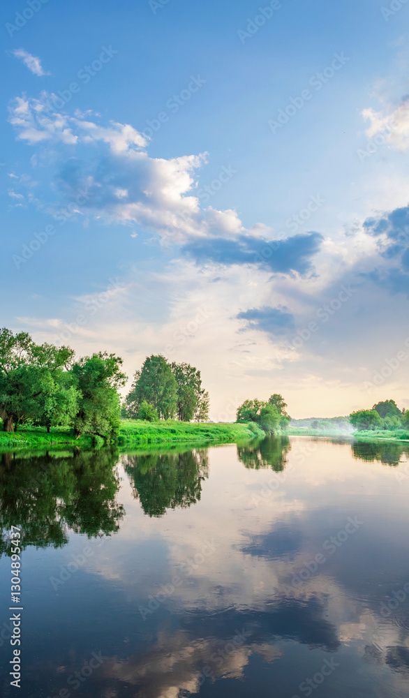 Calm lake with trees in the background and a cloudy sky Calm lake with trees in the background and a cloudy sky