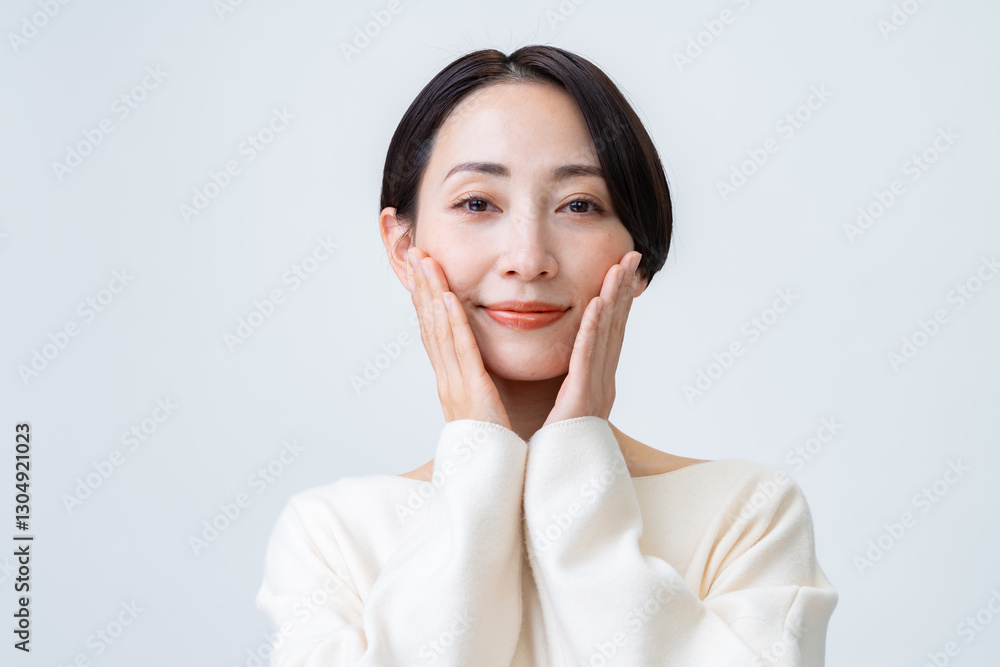 頬に手を当てる真面目な表情の女性 頬に手を当てる真面目な表情の女性