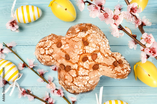 Colomba pasquale or Easter Dove is a traditional Italian dessert prepared with sourdough, almonds and candied fruit top view on colored background