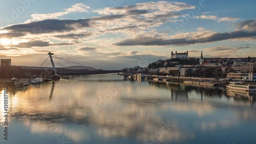Bratislava old town and SNP bridge at sunset over of calm Danube river hyper lapse. Slovakia.