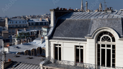 Toits élégants de Paris avec une façade haussmannienne sous un ciel bleu limpide