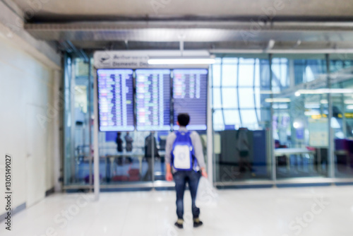 Blurred View of Passenger at Airport Departure looking at flight board.