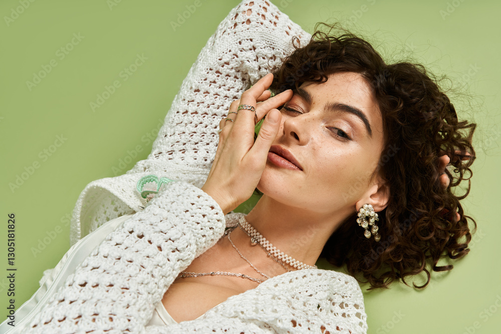 Φωτογραφία Young woman with curly hair poses gracefully, showcasing her beauty and stylish accessories