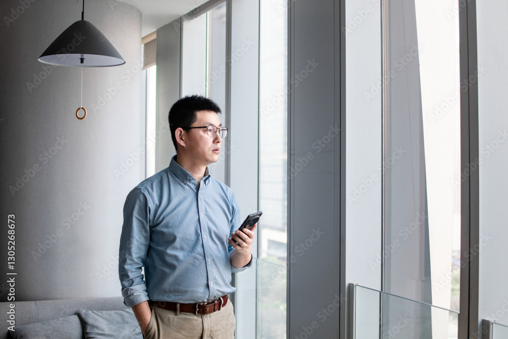 asian man using smart phone in modern office asian man using smart phone in modern office