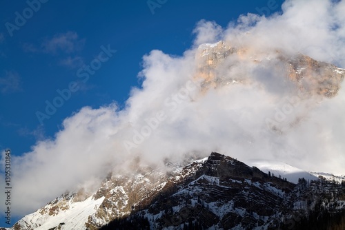 clouds over the snow covered mountains
