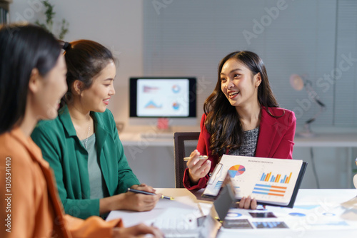 Photography Asian businesswomen reviewing financial charts, collaborating on company perform