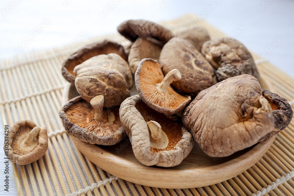 Fototapeta premium Dried mushrooms in wooden plate , Deied shiitake mushrooms on white background