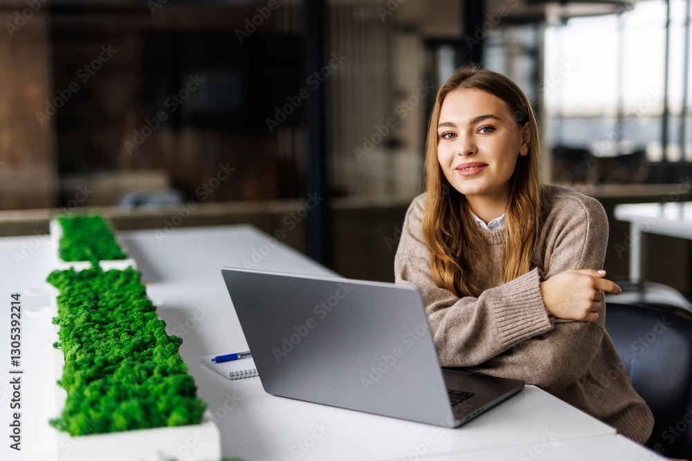 Beautiful joyful woman smiling while working with laptop in freelance office Beautiful joyful woman smiling while working with laptop in freelance office