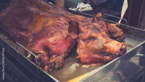 Traditional Ecuadorian Roast Pig “Chancho Hornado” at a Food Market. Whole roasted pig, known as “chancho hornado,” displayed at a food market. A traditional Ecuadorian dish enjoyed during festivities