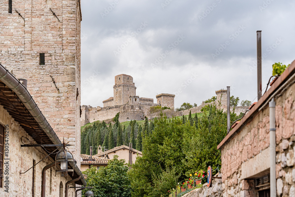 Fototapeta premium A castle with a large tower and a small tower in Assisi city in Italy Umbria