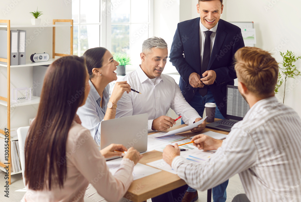 Fototapeta premium Happy business team working together in the office during a meeting or briefing. Successful and confident group in conversation, emphasizing effective communication and collaboration.
