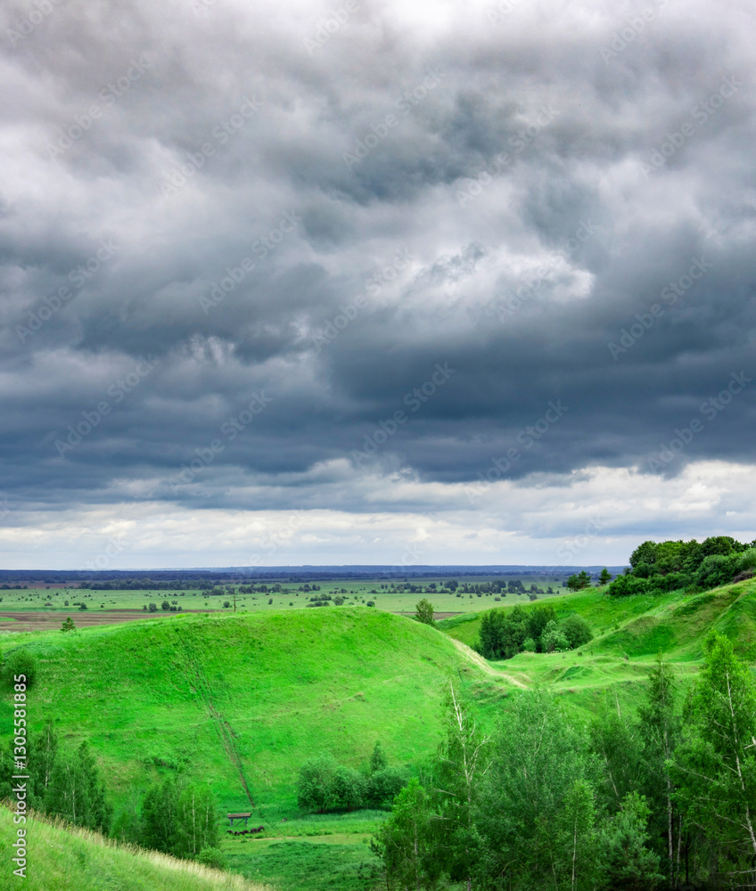 Fototapeta premium Cloudy sky with a green hill in the background