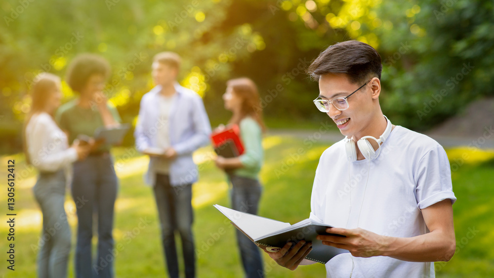Happy Chinese Male Student Resting At Campus After Classes, Standing Outdoors With Workbook, Checking Lessons Schedule, Free Space Happy Chinese Male Student Resting At Campus After Classes, Standing Outdoors With Workbook, Checking Lessons Schedule, Free Space