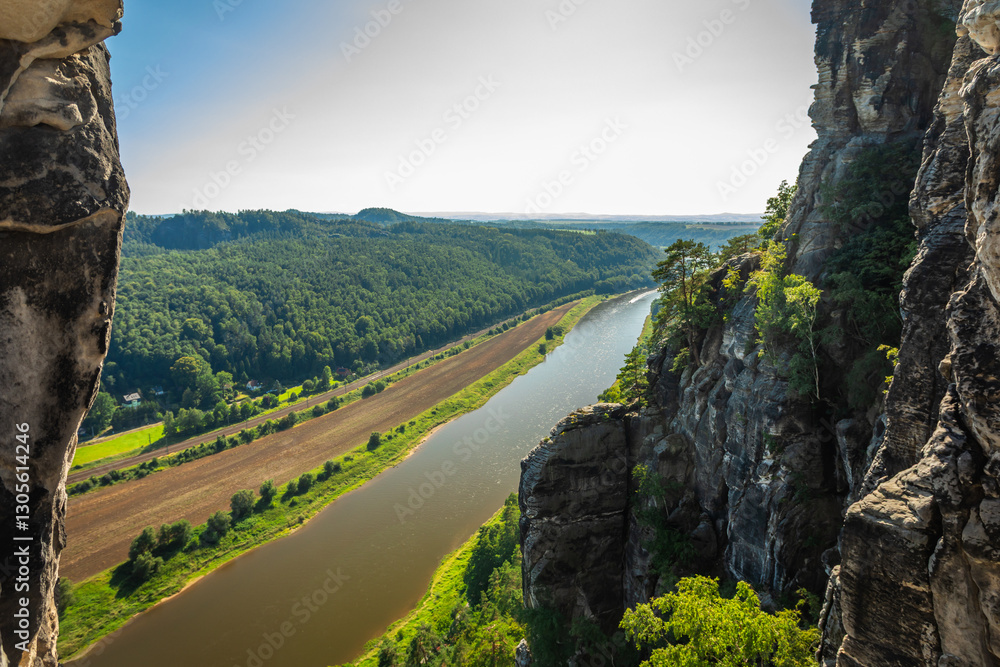 Obraz premium The Elbe River surrounded by the Elbe Valley Landscape, seen from the Elbe Sandstone Mountains on a sunny Summer Day; Copy Space