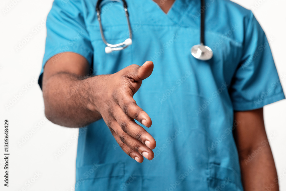 A millennial African American man doctor wearing scrubs is reaching out with an open hand, signaling readiness to engage with patients in a hospital or clinic setting. A millennial African American man doctor wearing scrubs is reaching out with an open hand, signaling readiness to engage with patients in a hospital or clinic setting.