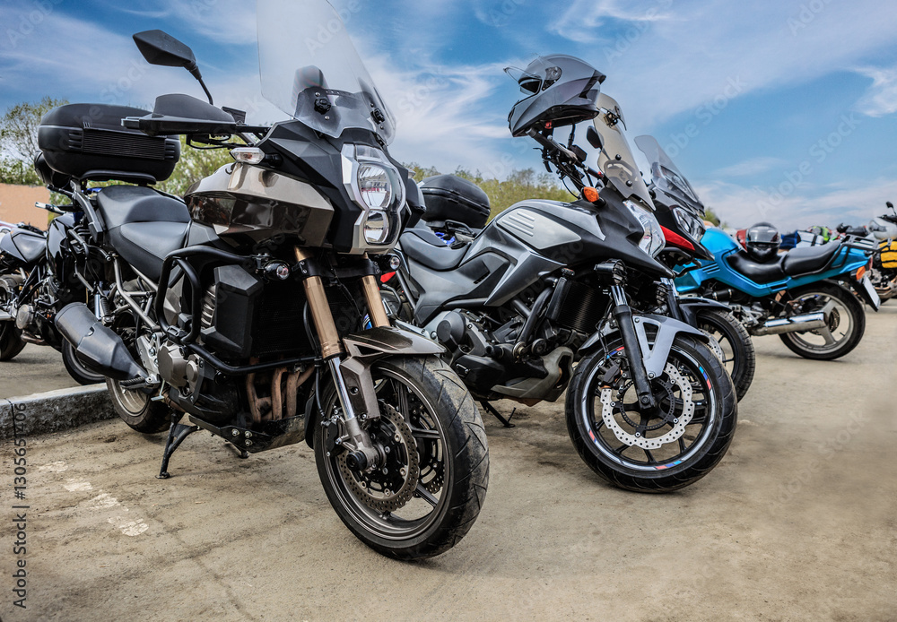 Motorcycles in parking lot under blue cloudy sky Motorcycles in parking lot under blue cloudy sky