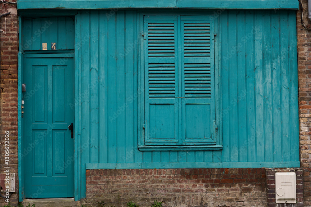 A vibrant blue wooden facade with a charming door and matching shutters, showcasing its rustic charm A vibrant blue wooden facade with a charming door and matching shutters, showcasing its rustic charm