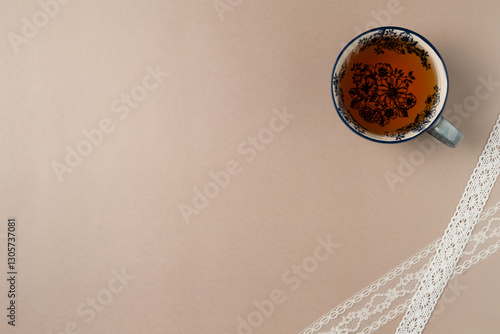 Cup of tea on beige background from above. Flat lay, top view. Copy space