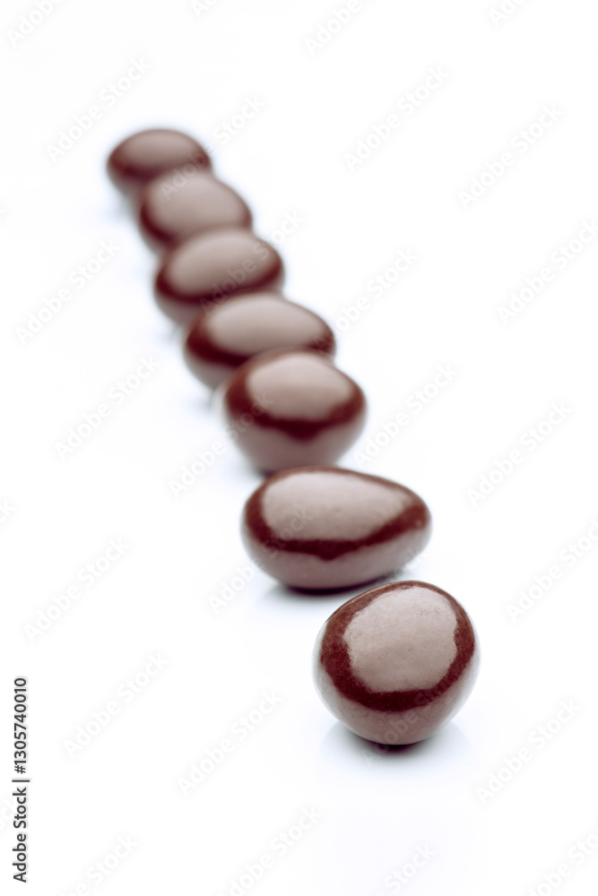 Chocolate eggs candy forming a diagonal line on white background Chocolate eggs candy forming a diagonal line on white background