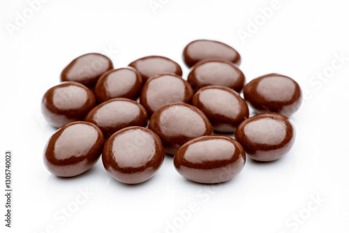 Chocolate raisins covered with milk chocolate lying on white background