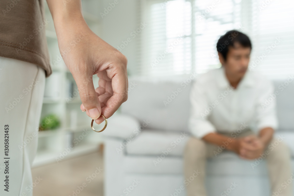 Fototapeta premium Woman take off married ring. Couples desperate and disappointed after marriage. Husband wife sad, upset and frustrated after quarrels conflict. distrust, love problems, betrayals, family, lover