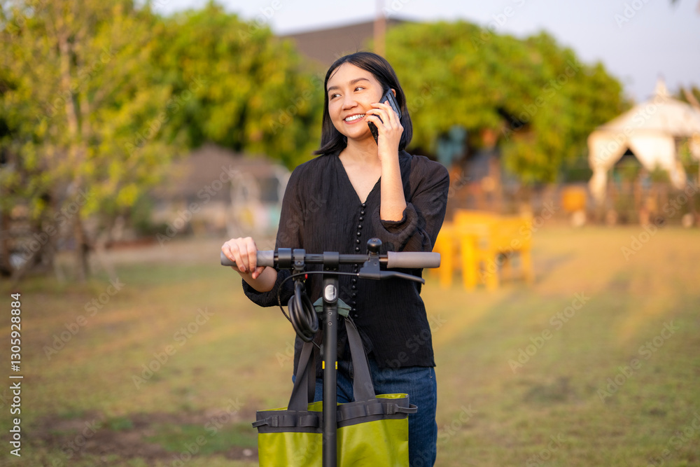 Fototapeta premium A woman is talking on her cell phone while riding a scooter