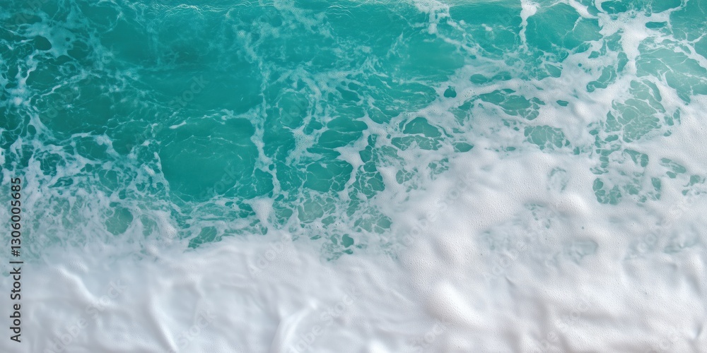 Obraz premium An overhead shot captures the beautiful contrast of turquoise ocean waves cresting and crashing against a serene sandy beach, showcasing nature's artistry and power.