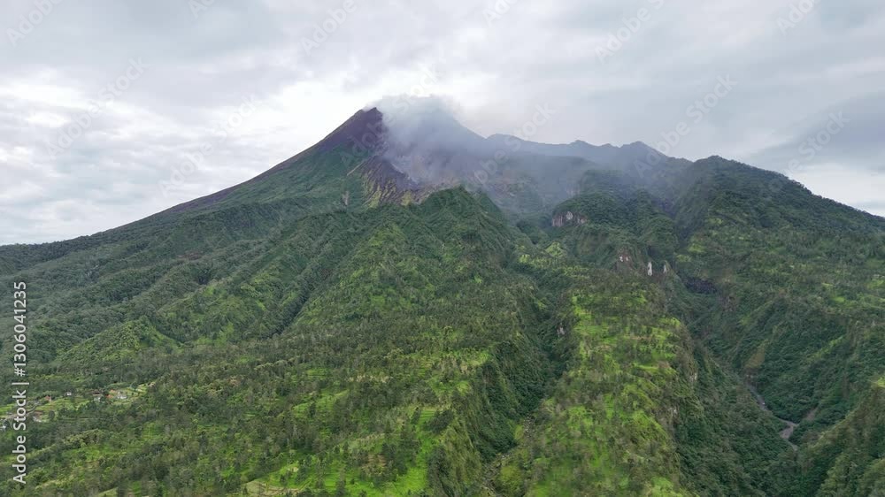 Aerial view of active tropical volcano emitting smoke from the top. Mount Merapi, Java, Indonesia. 4K drone footage of natural landscape. Aerial view of active tropical volcano emitting smoke from the top. Mount Merapi, Java, Indonesia. 4K drone footage of natural landscape.
