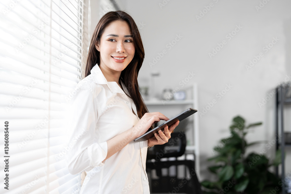 Portrait of happy businesswoman with touchpad in office looking outside. Portrait of happy businesswoman with touchpad in office looking outside.
