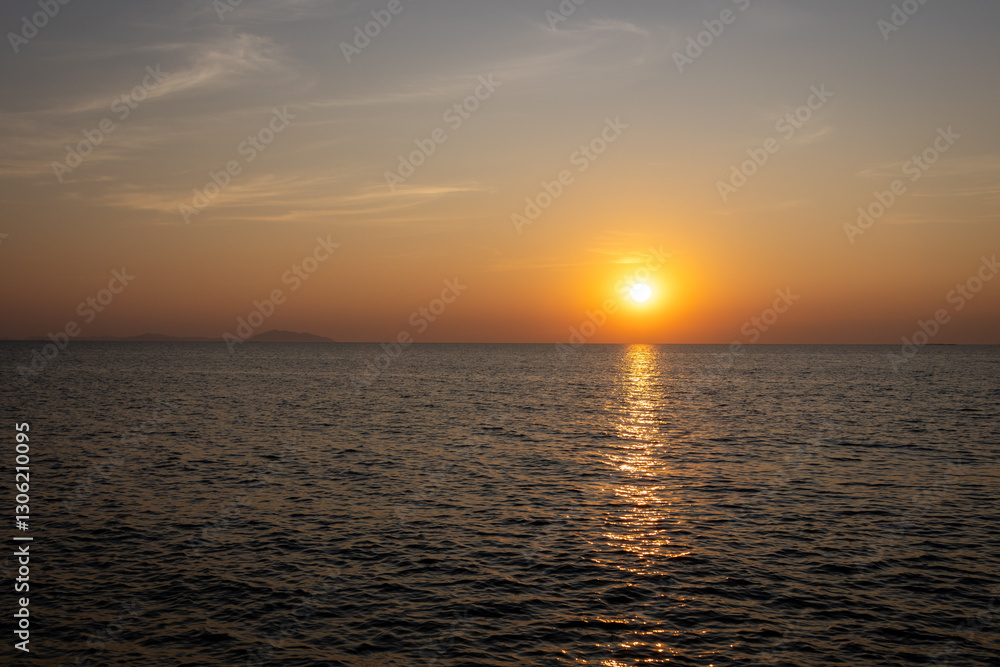 Obraz premium serene sunset view over the ocean, with the sun casting a warm golden reflection